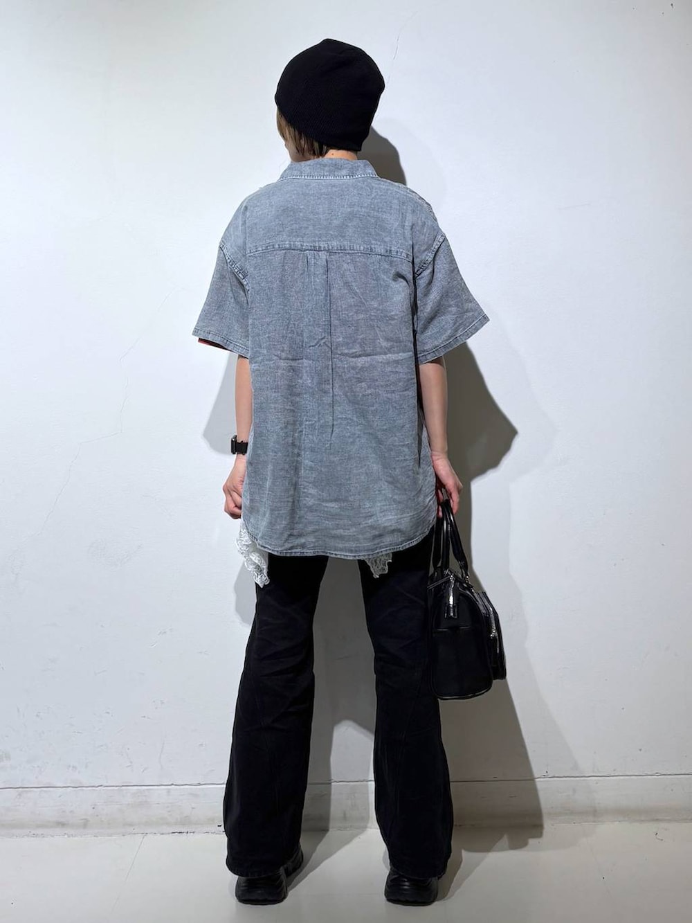 ブラック系のデニムパンツ、ブラック系のショルダーバッグ、ブルー系のシャツ/ブラウスを着用したレディースの春コーディネートの5枚目の写真