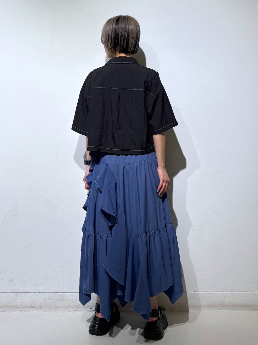 ブルー系のスカート、グレー系のTシャツ/カットソー、ブラック系のサンダルを着用したレディースの春コーディネートの4枚目の写真