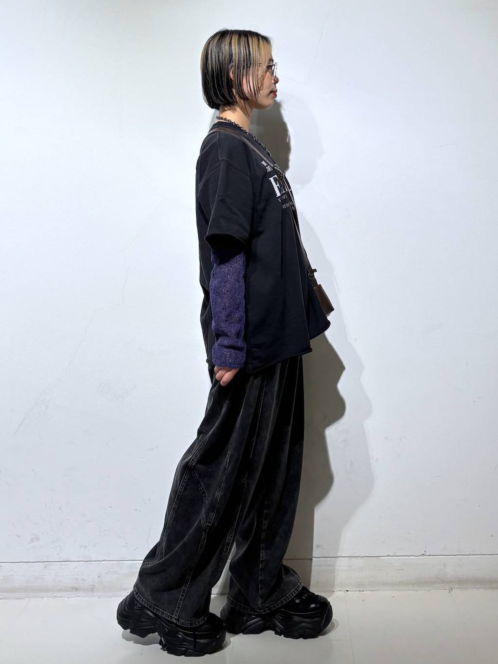 ブラック系のスニーカー、ブラウン系のショルダーバッグ、ブラック系のデニムパンツを着用したレディースの春コーディネートの4枚目の写真