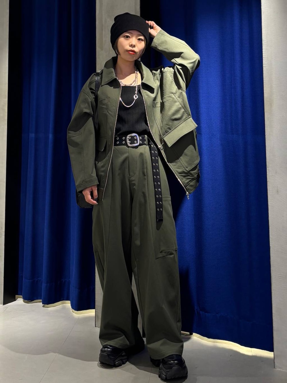 ブラック系のスニーカー、ブラック系のタンクトップ、グリーン系のカーゴパンツを着用したレディースの春コーディネートの3枚目の写真