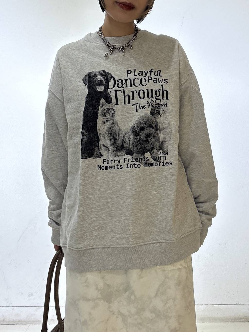 ブラック系のスニーカー、ベージュ系のボストンバッグ、ホワイト系のスカートを着用したレディースの冬コーディネートの7枚目の写真