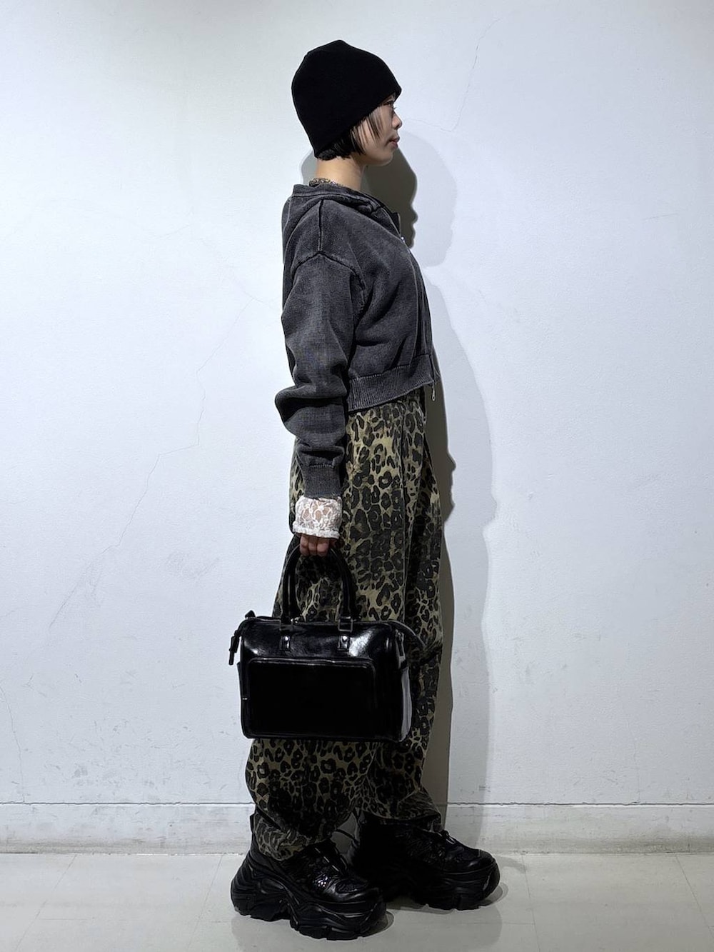 ブラック系のスニーカー、ホワイト系のTシャツ/カットソー、ブラウン系のデニムパンツを着用したレディースの冬コーディネートの4枚目の写真