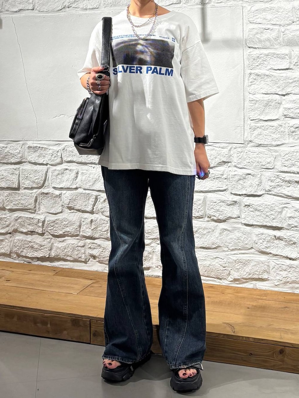 ホワイト系のTシャツ/カットソー、ブルー系のデニムパンツ、ブラック系のショルダーバッグを着用したレディースの夏コーディネートの3枚目の写真