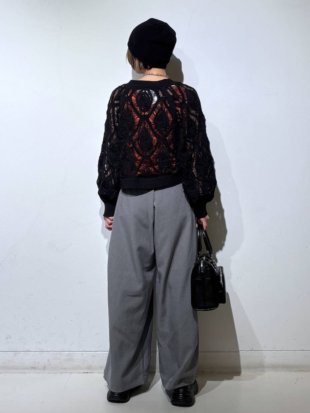 ブラック系のカーディガン/ボレロ、グレー系のスラックス、グレー系のタンクトップを着用したレディースの春コーディネートの5枚目の写真