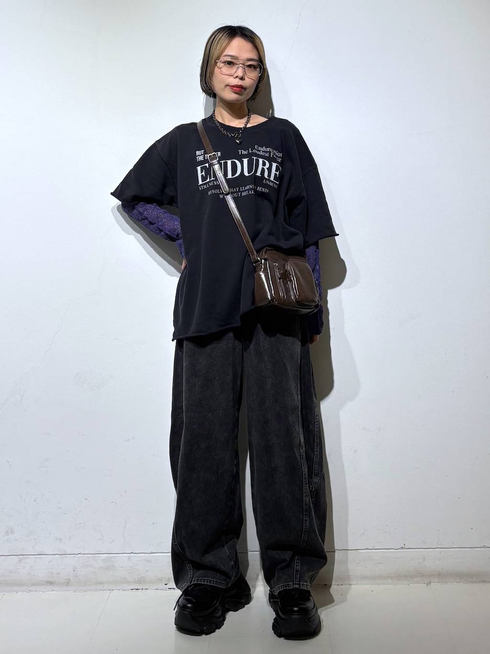 ブラック系のスニーカー、ブラウン系のショルダーバッグ、ブラック系のデニムパンツを着用したレディースの春コーディネートの2枚目の写真