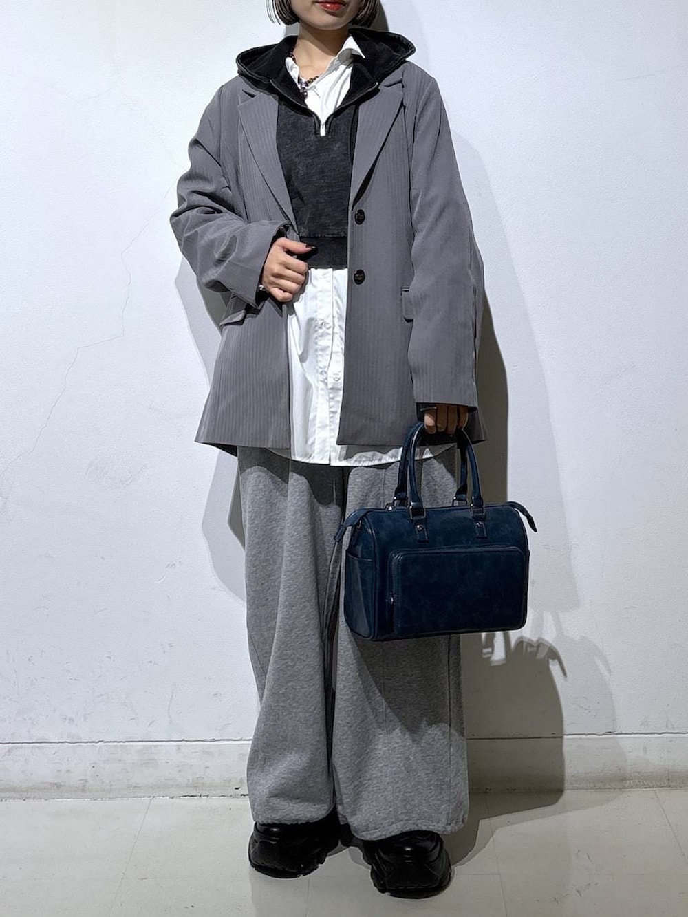 ブラック系のスニーカー、グレー系のテーラードジャケット、グレー系のパーカーを着用したレディースの冬コーディネートの2枚目の写真