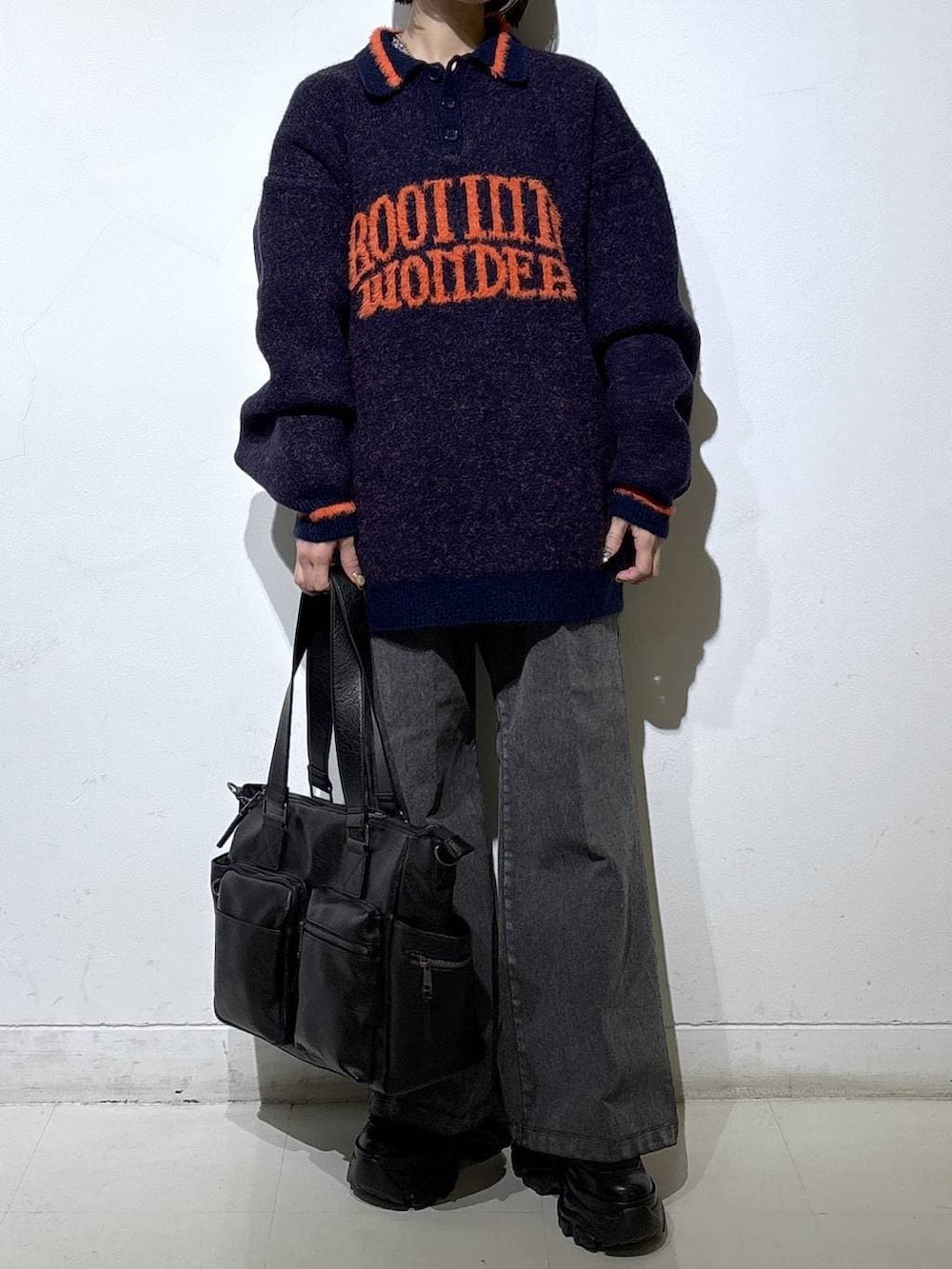 ブラック系のブーツ、ブラック系のボストンバッグ、ブルー系のニット/セーターを着用したレディースの秋コーディネートの2枚目の写真