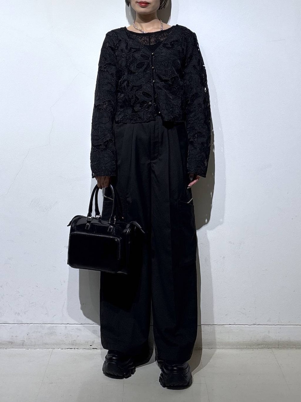 ブラック系のスニーカー、ブラック系のキャミソール、ブラック系のショルダーバッグを着用したレディースの春コーディネートの2枚目の写真