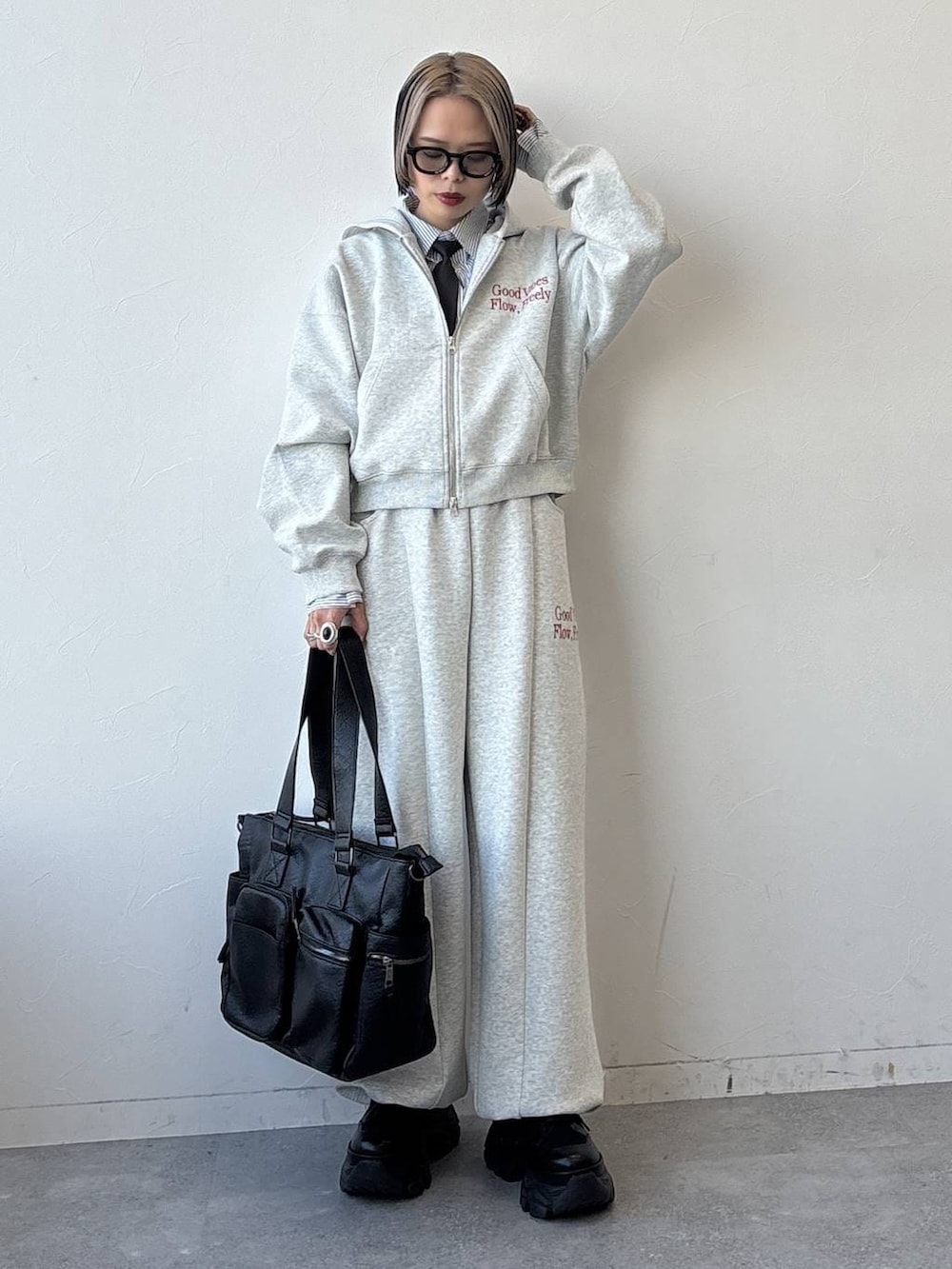 ブラック系のスニーカー、ブラック系のボストンバッグ、グレー系のパーカーを着用したレディースの冬コーディネートの5枚目の写真