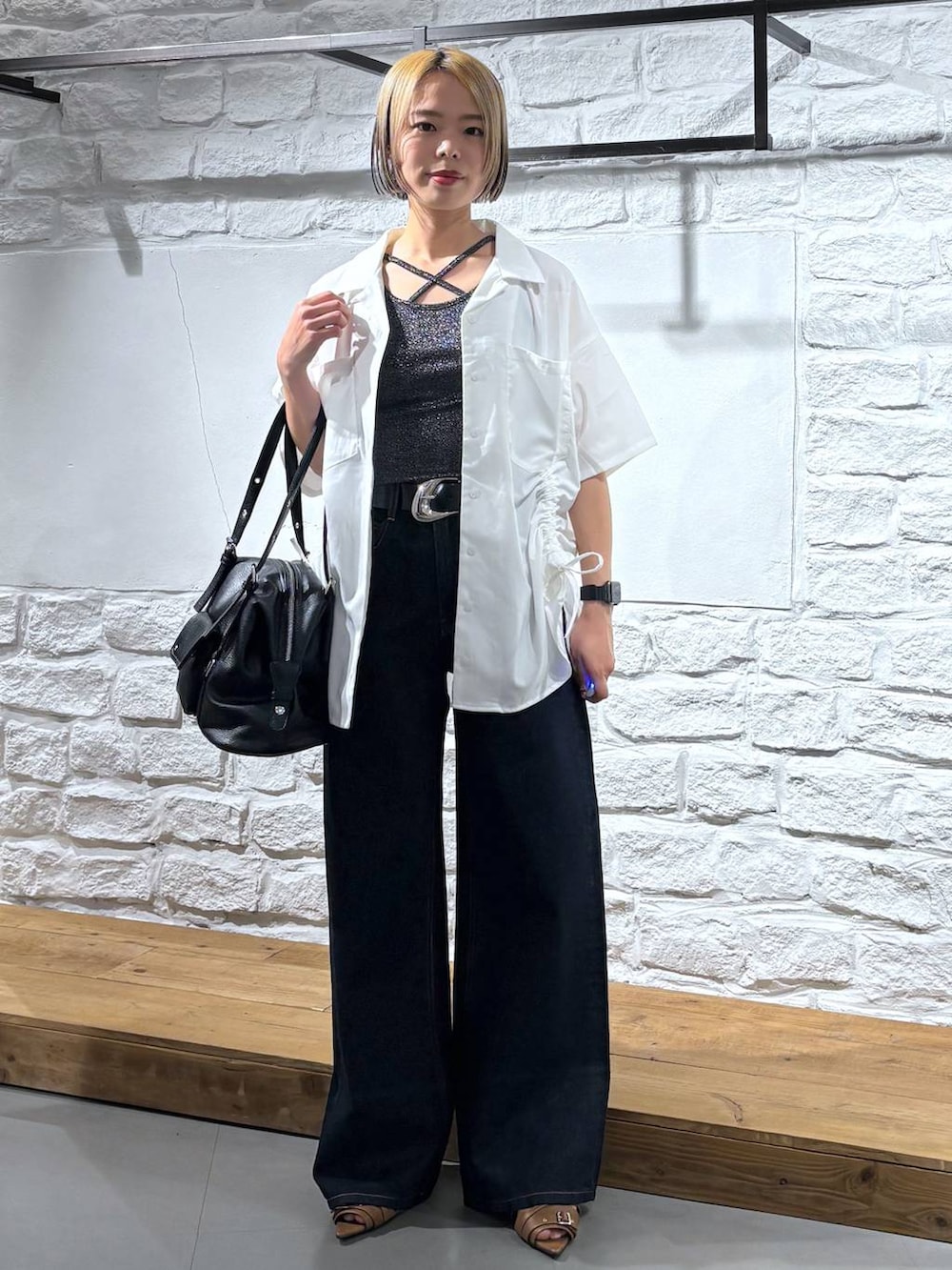 ブルー系のデニムパンツ、イエロー系のサンダル、ホワイト系のシャツ/ブラウスを着用したレディースの春コーディネートの2枚目の写真