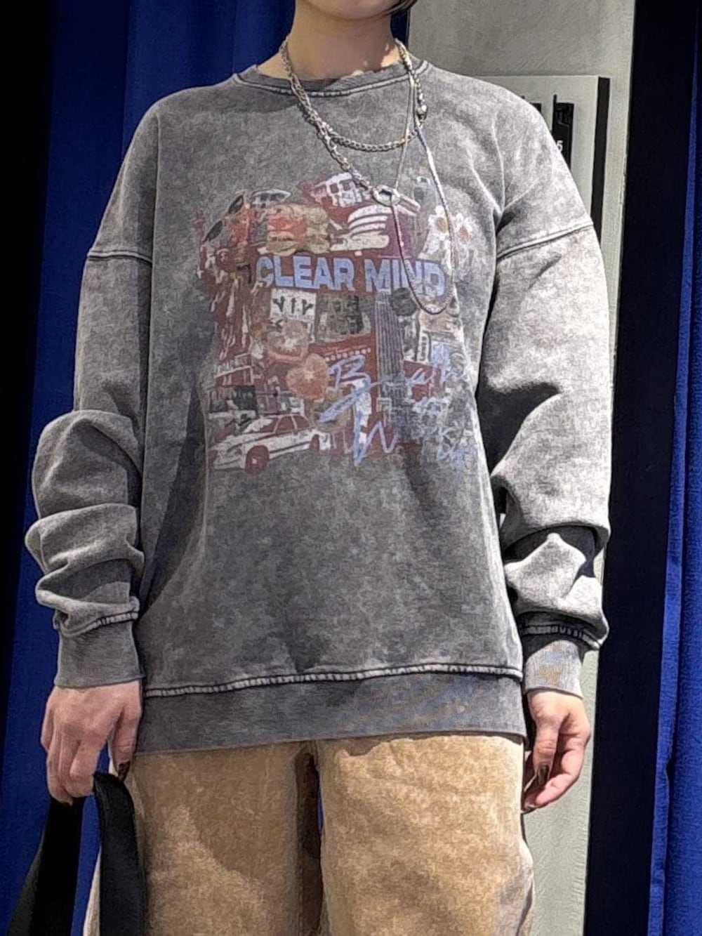 ブラック系のスニーカー、ブラック系のボストンバッグ、ブラウン系のデニムパンツを着用したレディースの冬コーディネートの3枚目の写真