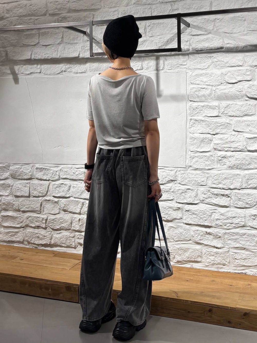 ブラック系のデニムパンツ、グレー系のサンダル、ベージュ系のTシャツ/カットソーを着用したレディースの夏コーディネートの6枚目の写真
