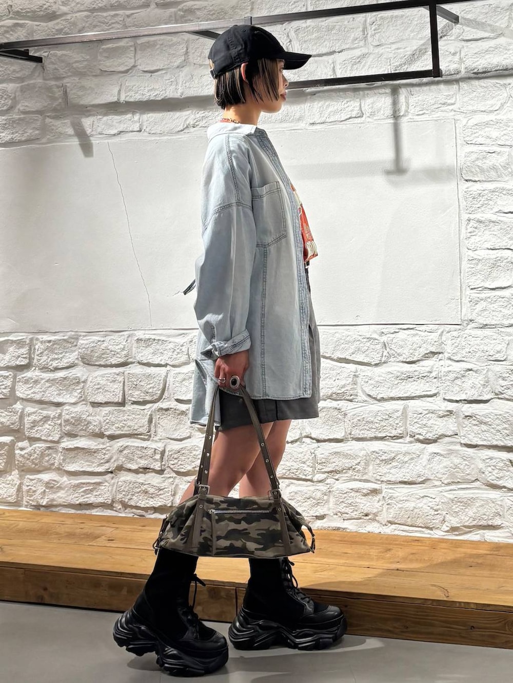ブラック系のブーツ、ブルー系のシャツ/ブラウス、レッド系のTシャツ/カットソーを着用したレディースの春コーディネートの4枚目の写真