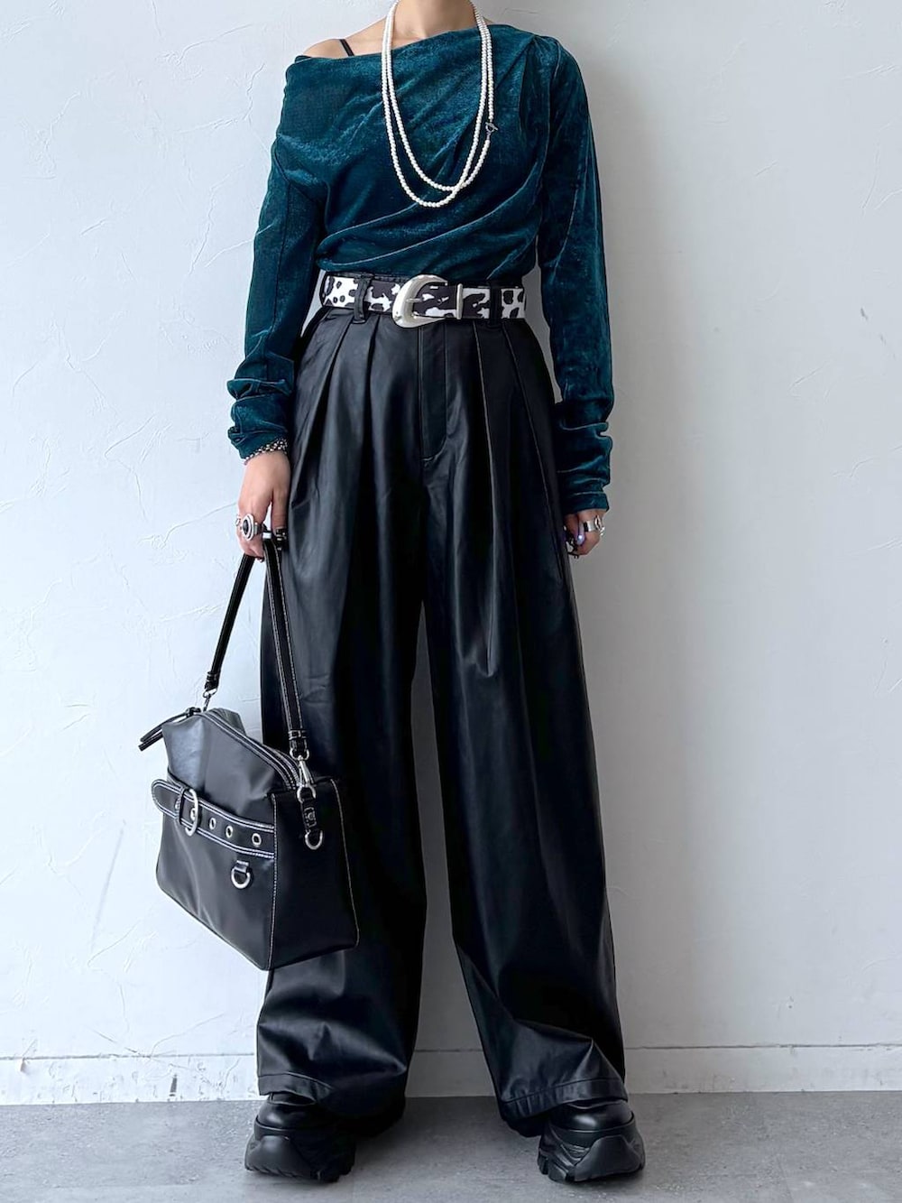 ブラック系のスニーカー、ブラック系のスラックス、ブルー系のTシャツ/カットソーを着用したレディースの秋コーディネートの3枚目の写真