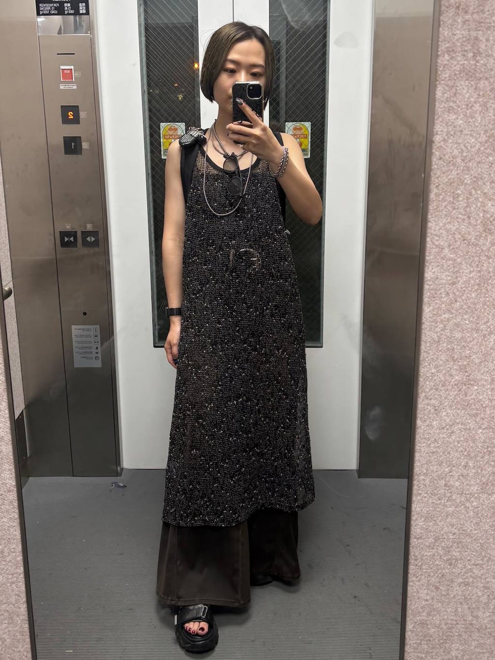 ブラウン系のデニムパンツ、ブラック系のサンダル、ブラック系のワンピースを着用したレディースの夏コーディネートの7枚目の写真