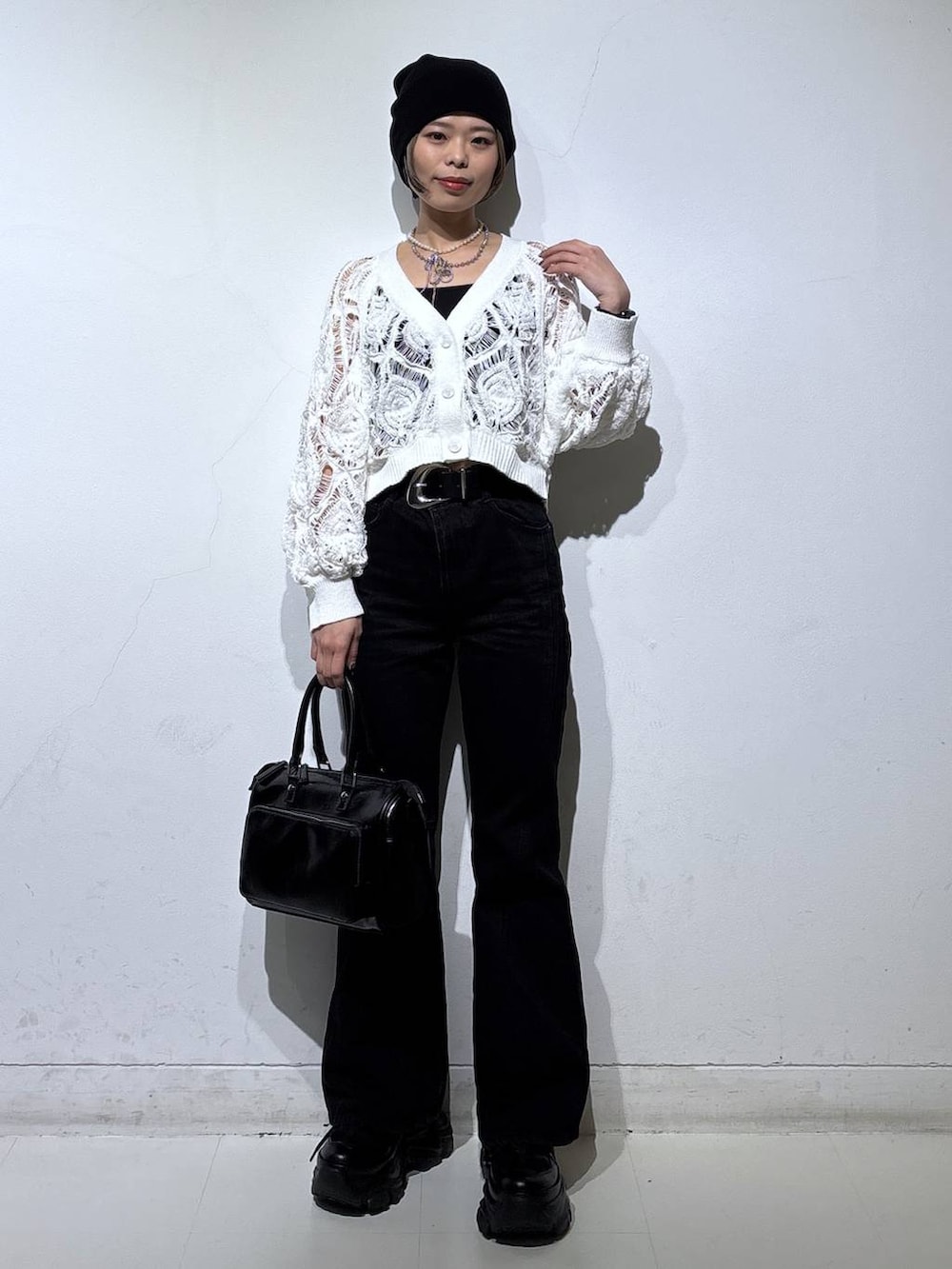 ブラック系のスニーカー、ブラック系のキャミソール、ホワイト系のカーディガン/ボレロを着用したレディースの春コーディネートの3枚目の写真