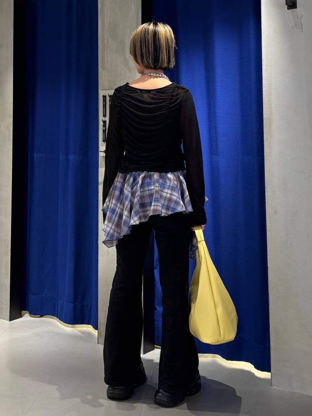 ブラック系のスニーカー、ブラック系のデニムパンツ、イエロー系のトートバッグを着用したレディースの春コーディネートの4枚目の写真