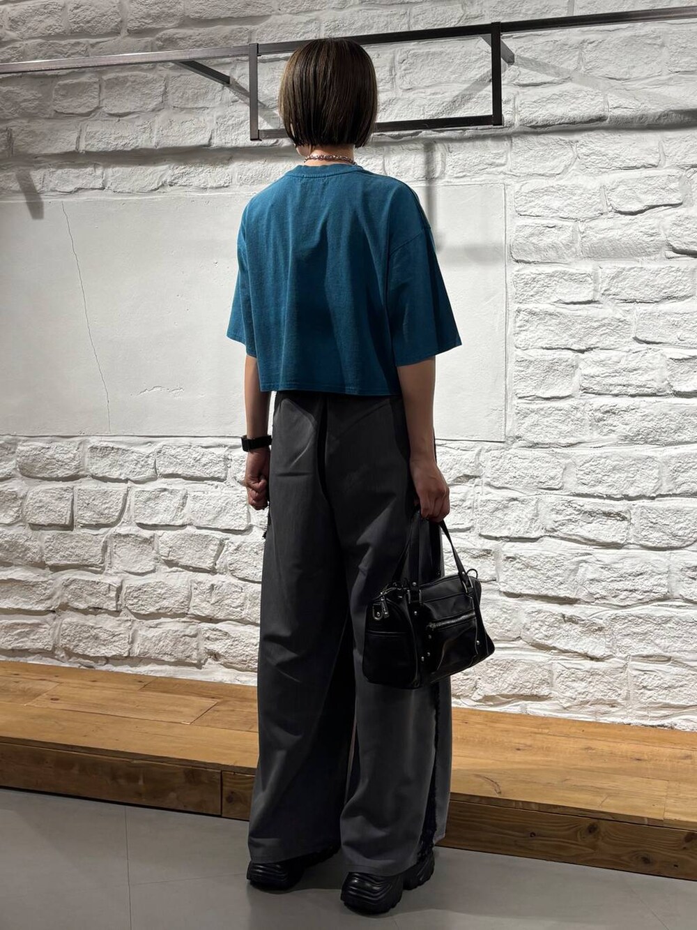 ブラック系のショルダーバッグ、ブルー系のTシャツ/カットソー、ブラック系のサンダルを着用したレディースの夏コーディネートの6枚目の写真