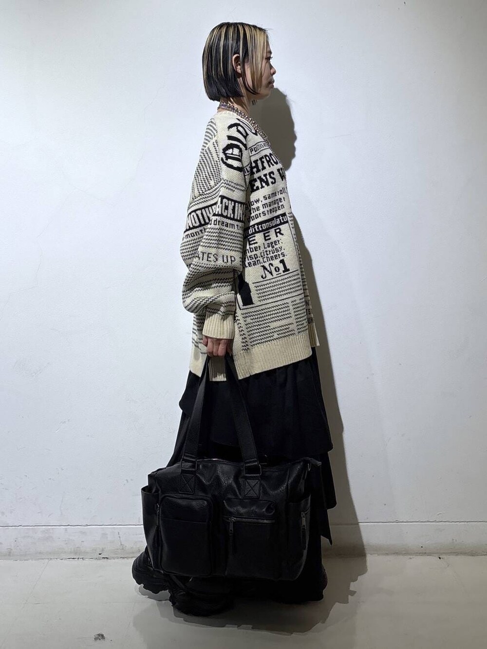 ブラウン系のブーツ、ブラック系のボストンバッグ、ブラック系のスカートを着用したレディースの冬コーディネートの3枚目の写真