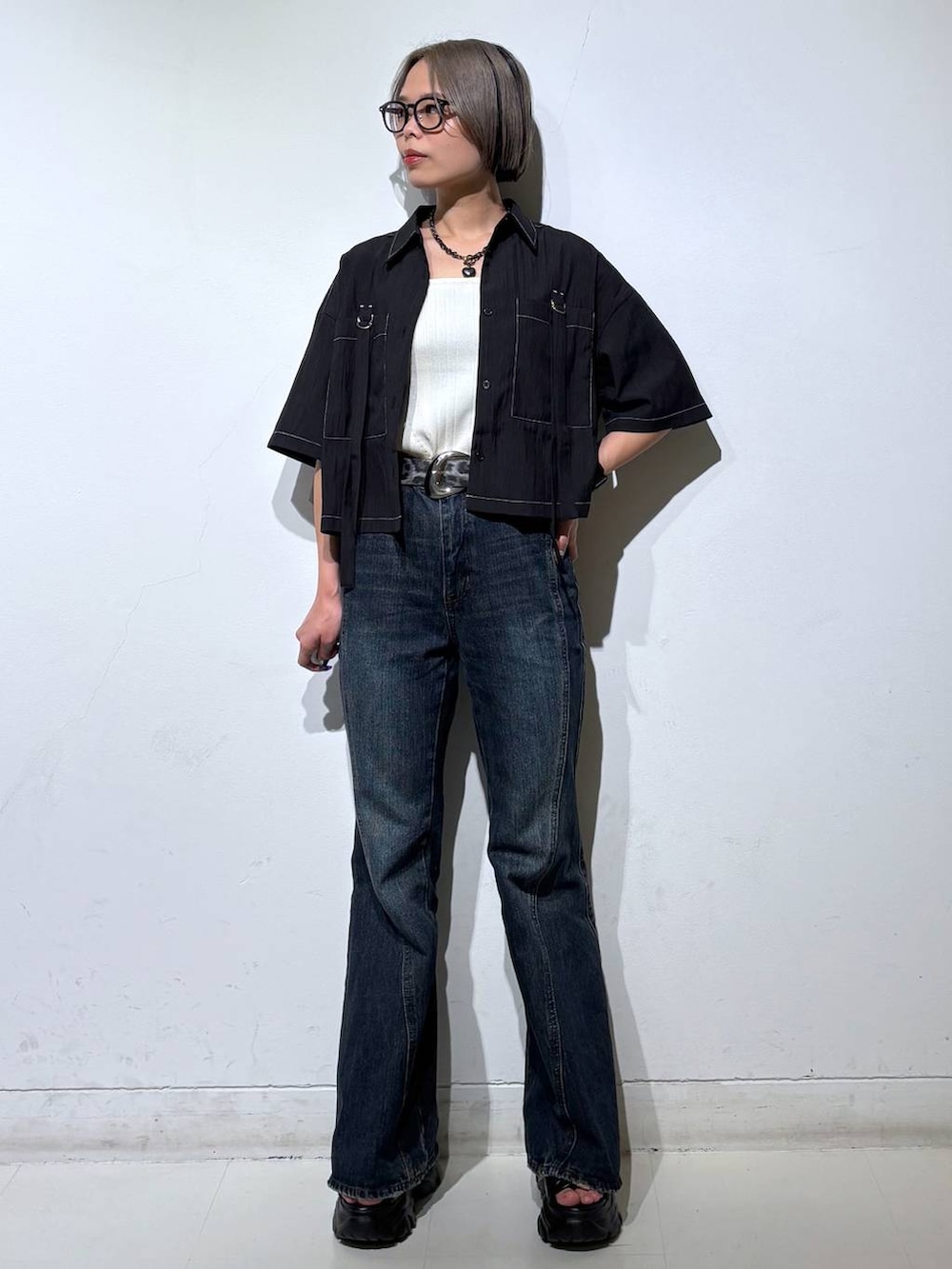 ブルー系のデニムパンツ、ホワイト系のタンクトップ、グレー系のサンダルを着用したレディースの春コーディネートの2枚目の写真
