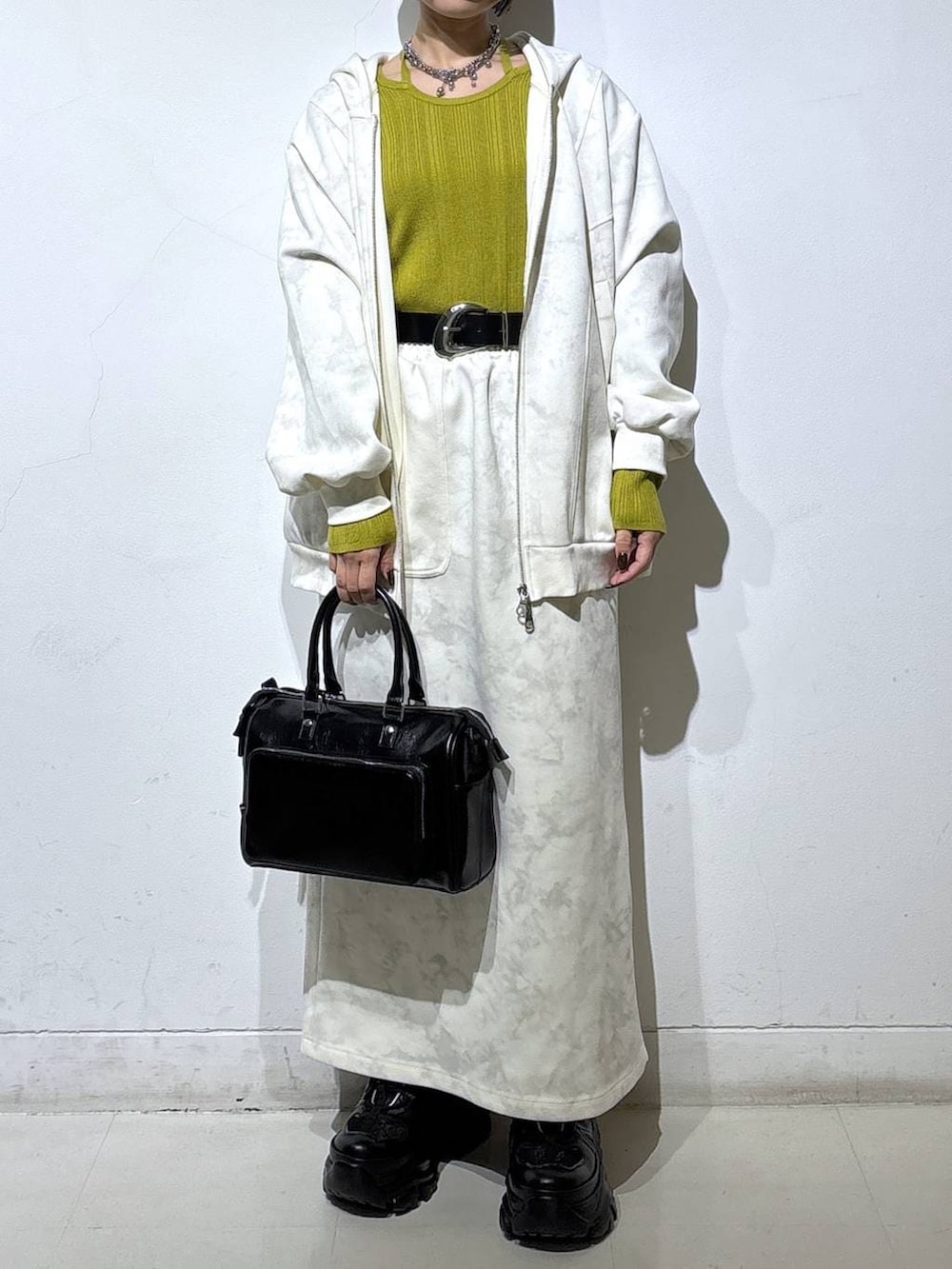 ブラック系のブーツ、ホワイト系のパーカー、ホワイト系のスカートを着用したレディースの冬コーディネートの2枚目の写真