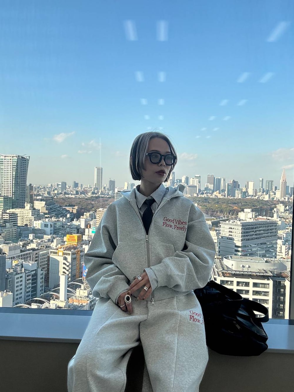 ブラック系のスニーカー、ブラック系のボストンバッグ、グレー系のパーカーを着用したレディースの冬コーディネートの2枚目の写真