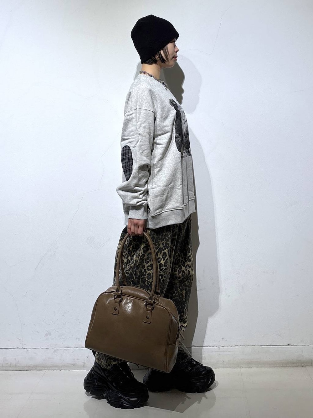 ブラック系のブーツ、ベージュ系のボストンバッグ、グレー系のスウェットを着用したレディースの冬コーディネートの4枚目の写真