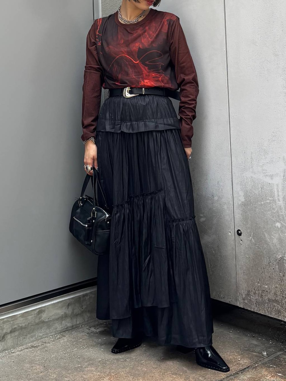 ブラック系のショルダーバッグ、ブラック系のスカート、ブラック系のサンダルを着用したレディースの夏コーディネートの3枚目の写真
