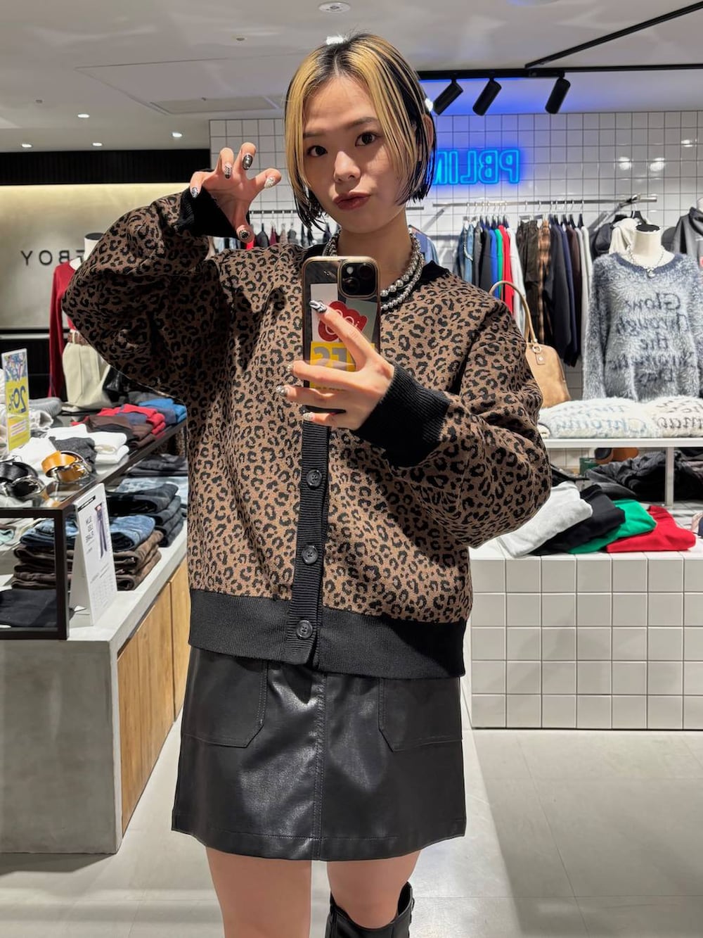 ブラック系のブーツ、ブラウン系のカーディガン/ボレロ、ブラック系のスカートを着用したレディースの秋コーディネートの2枚目の写真