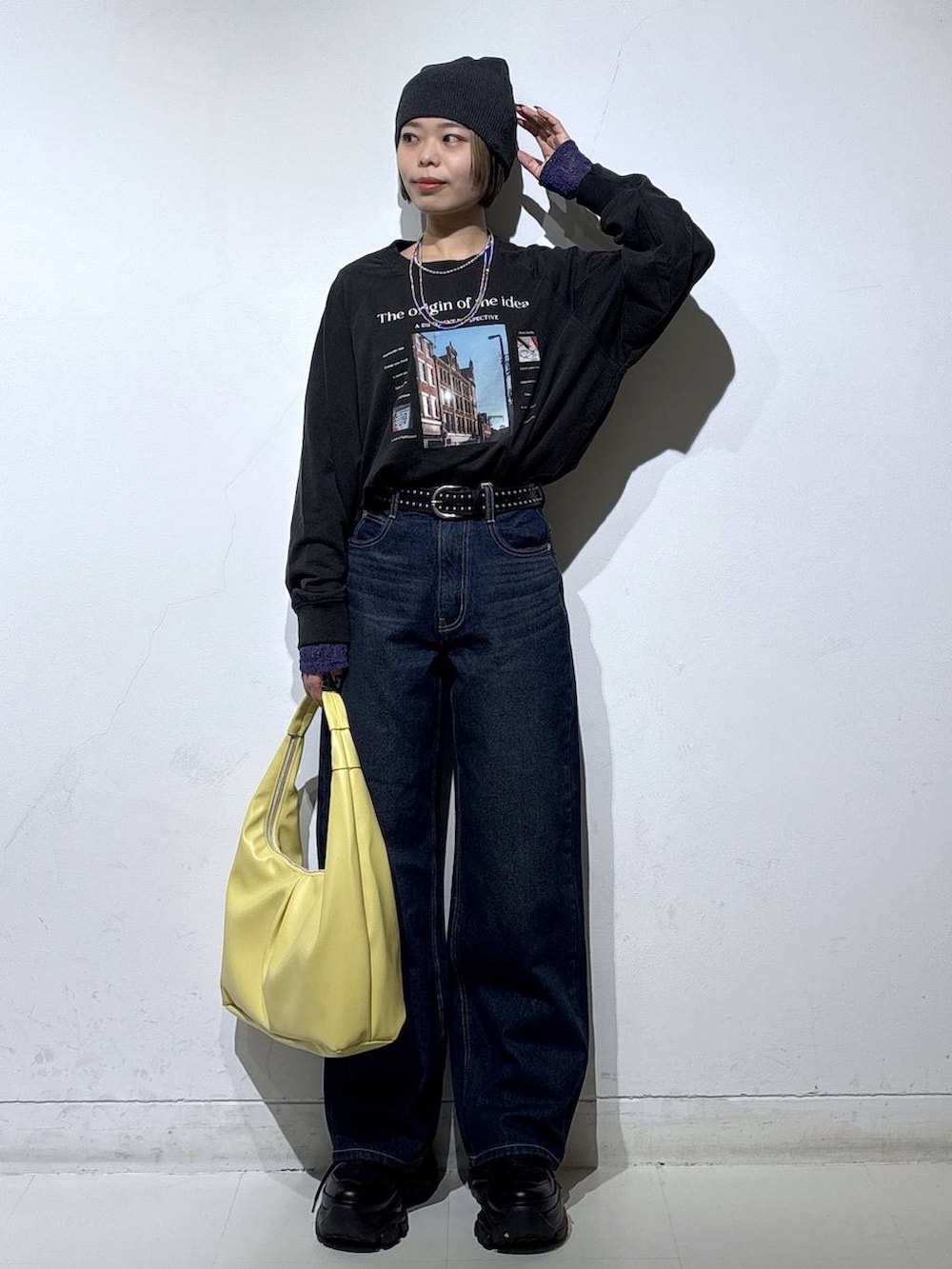 ブラック系のスニーカー、ブルー系のスラックス、イエロー系のトートバッグを着用したレディースの春コーディネートの2枚目の写真