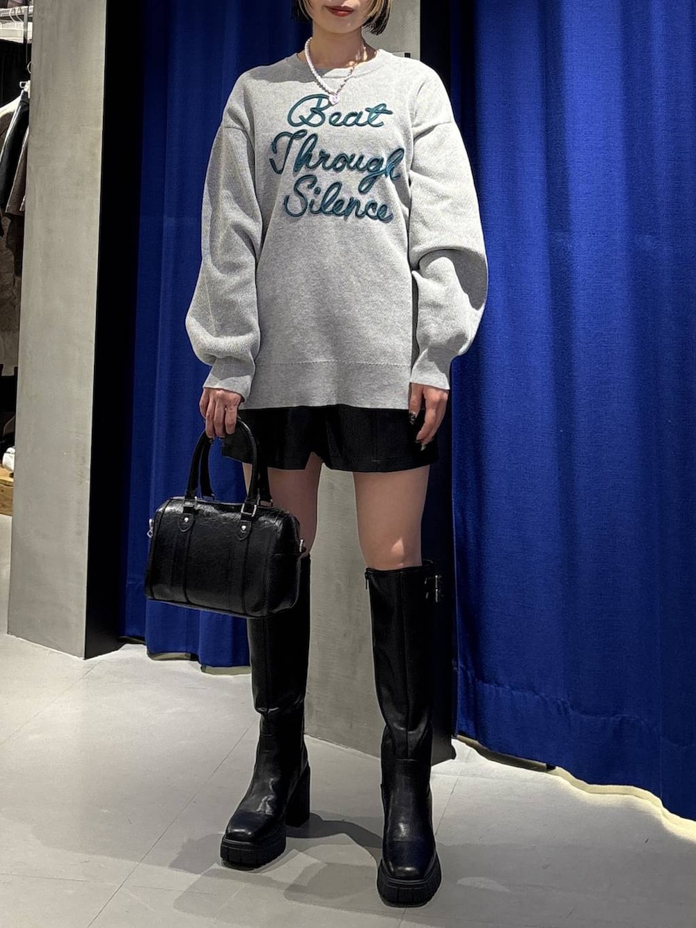 ブラック系のブーツ、ブラック系のその他パンツ、ブラック系のボストンバッグを着用したレディースの冬コーディネートの2枚目の写真