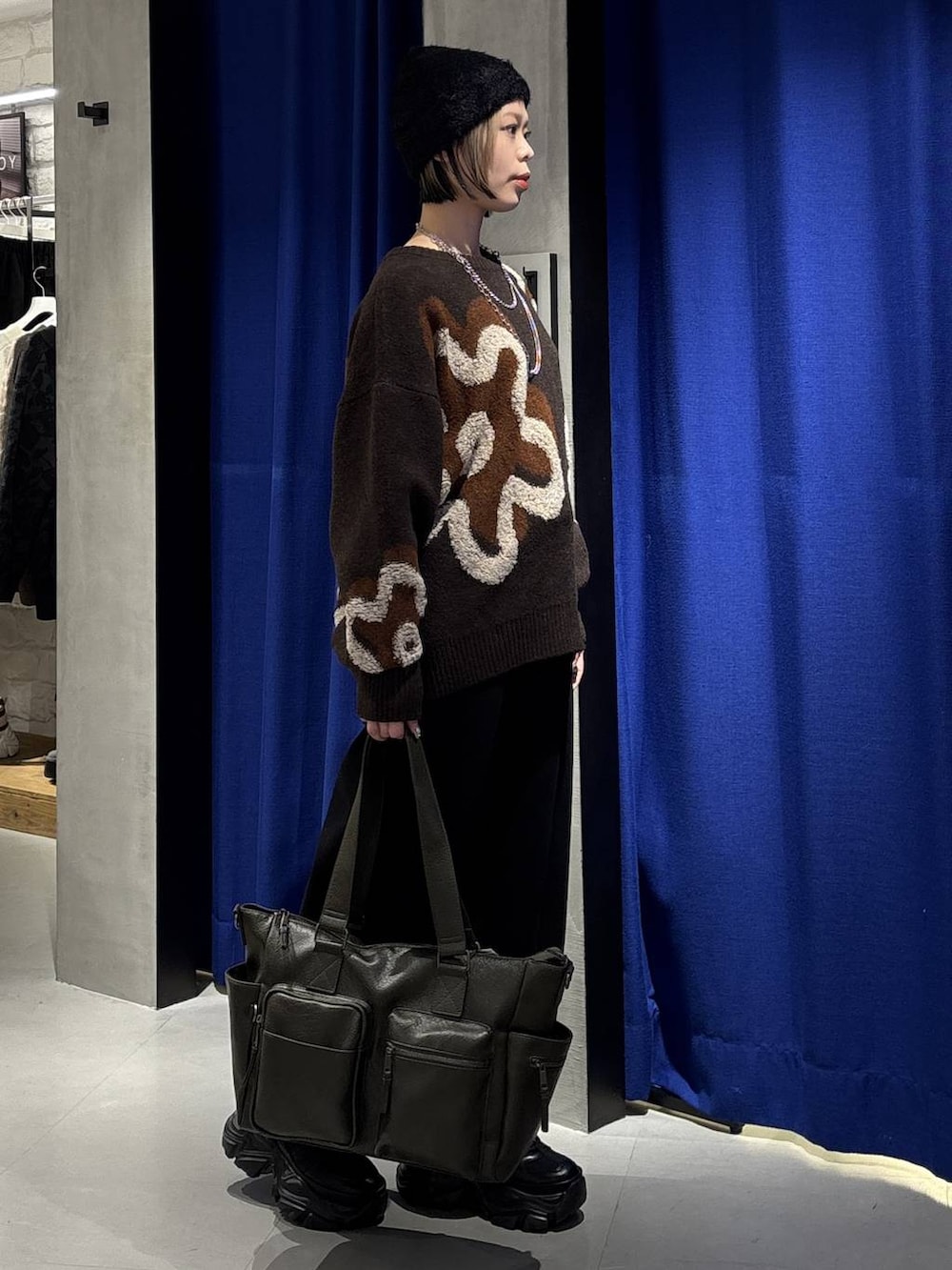 ブラック系のスニーカー、グリーン系のボストンバッグ、ブラウン系のニット/セーターを着用したレディースの冬コーディネートの4枚目の写真