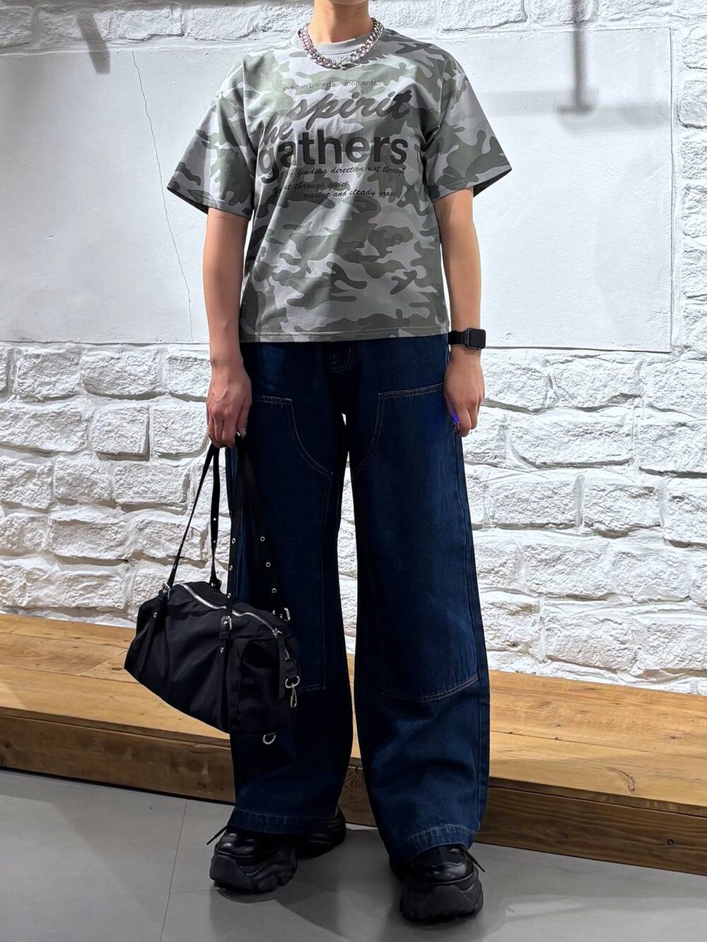 ブラック系のスニーカー、ブルー系のデニムパンツ、その他のTシャツ/カットソーを着用したレディースの春コーディネートの3枚目の写真