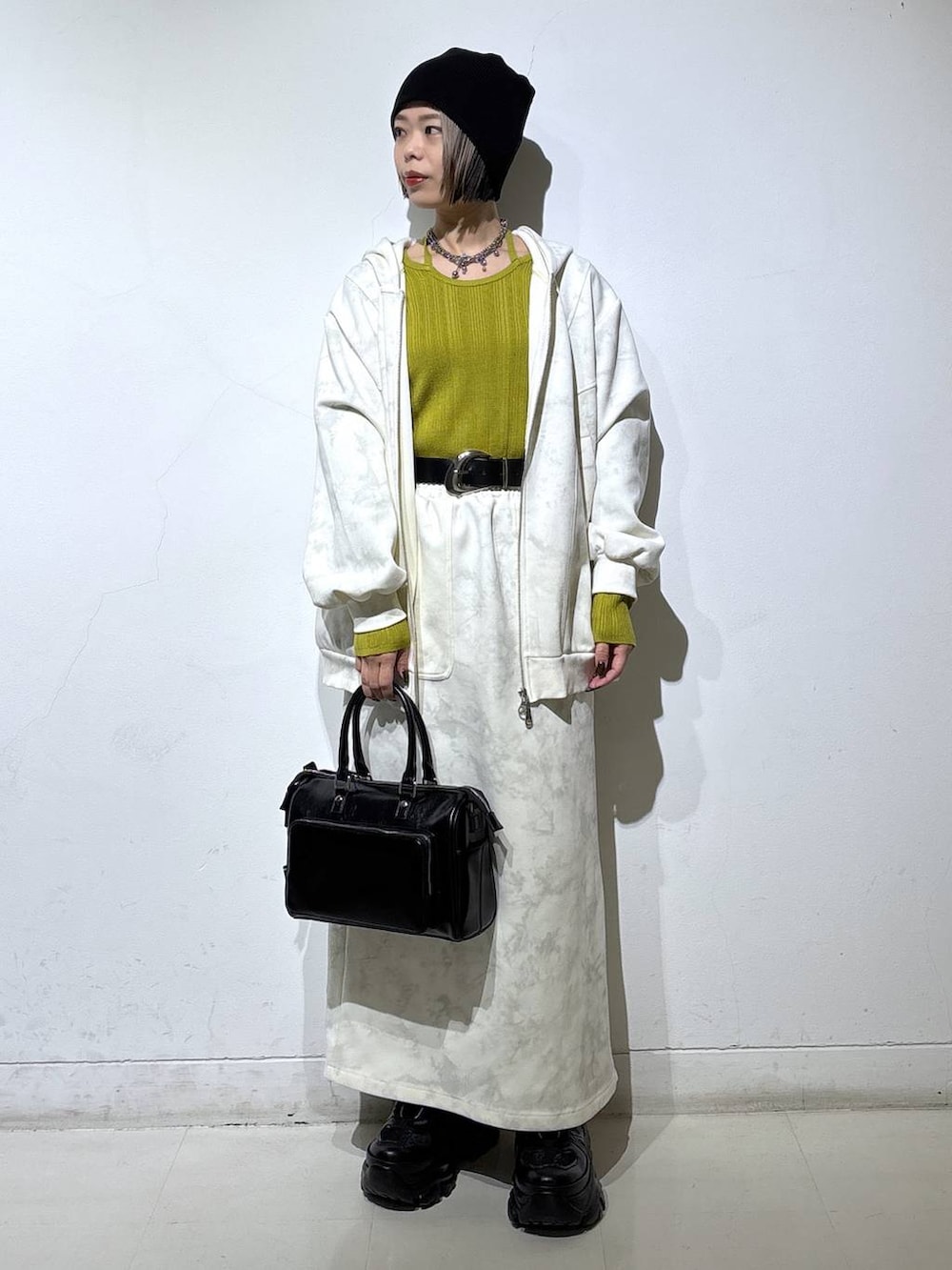 ブラック系のブーツ、ホワイト系のパーカー、ホワイト系のスカートを着用したレディースの冬コーディネートの3枚目の写真