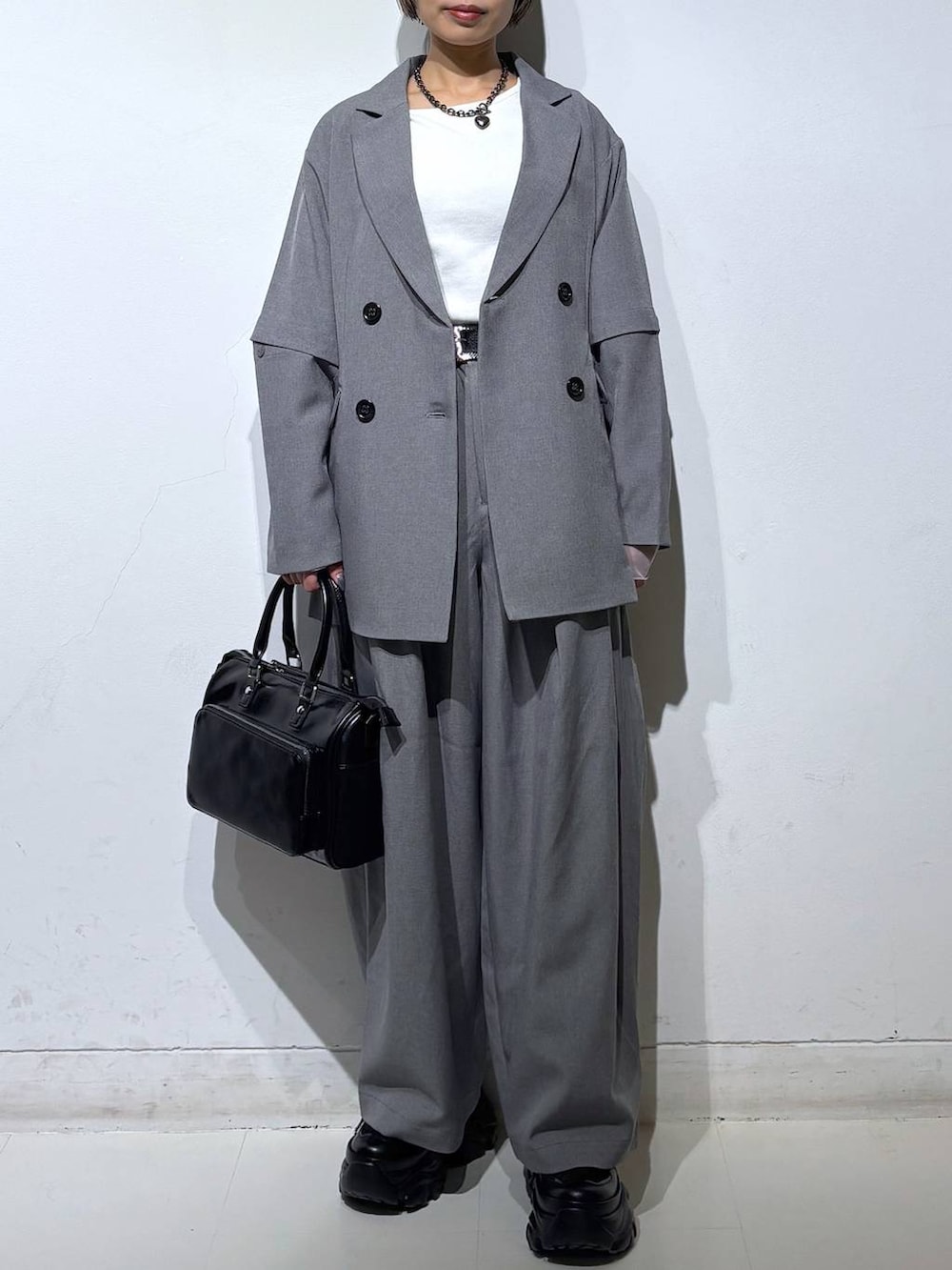 ブラック系のスニーカー、ブラック系のショルダーバッグ、ホワイト系のTシャツ/カットソーを着用したレディースの春コーディネートの2枚目の写真