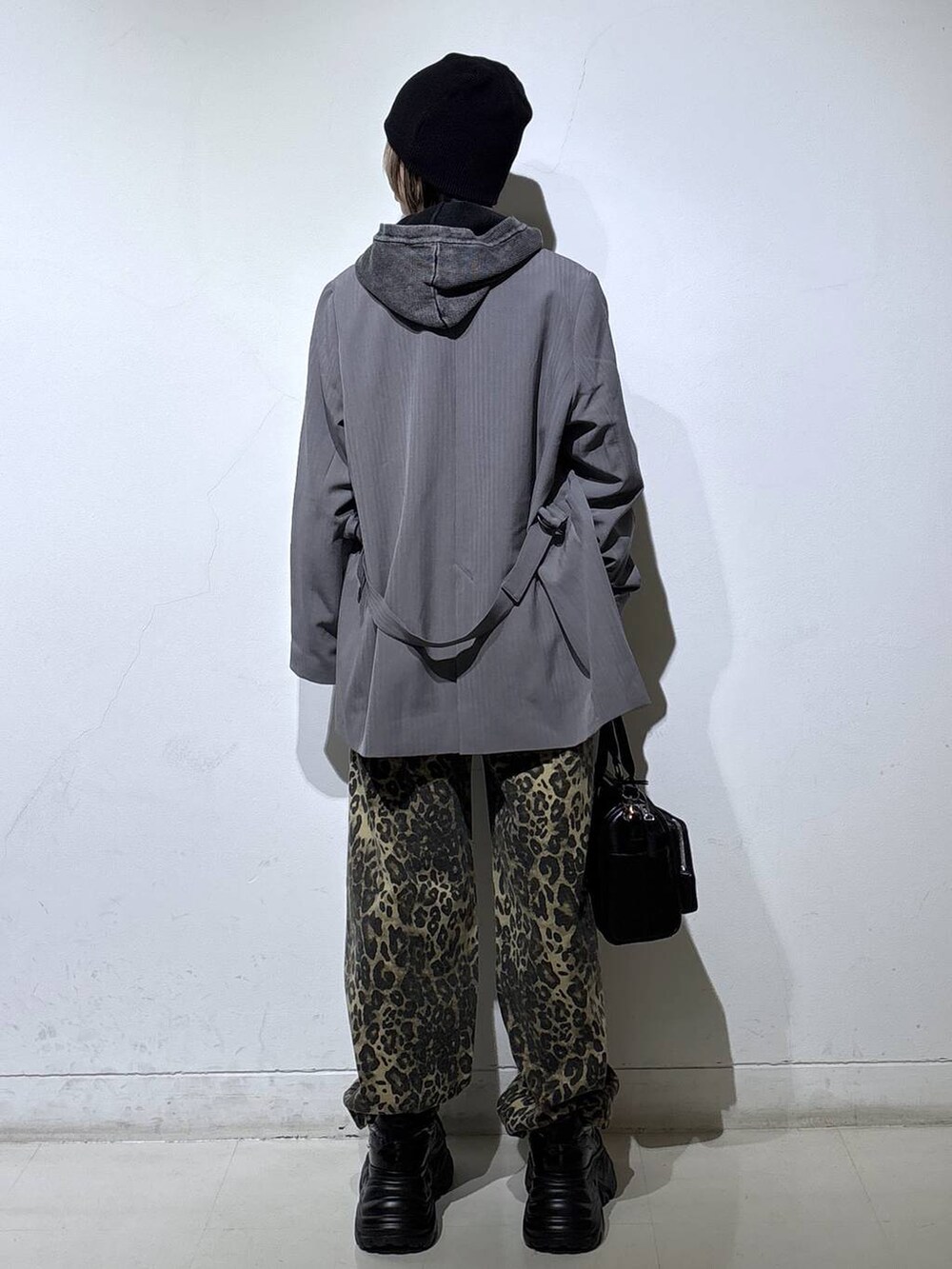 ブラック系のスニーカー、ホワイト系のTシャツ/カットソー、ブラウン系のデニムパンツを着用したレディースの冬コーディネートの4枚目の写真