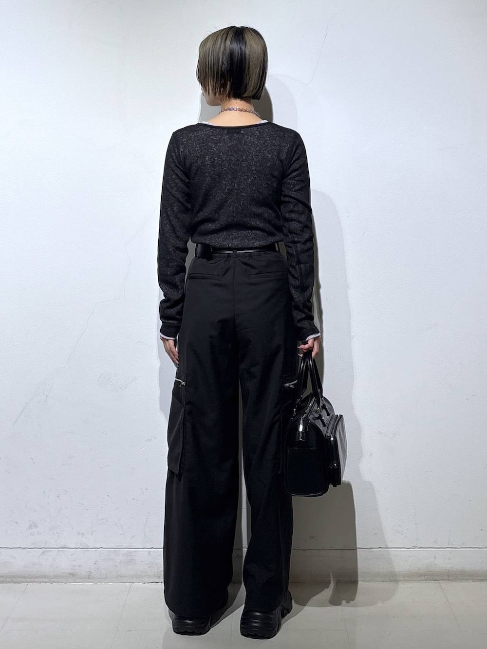 ブラック系のスニーカー、ブラック系のショルダーバッグ、ブラック系のスラックスを着用したレディースの冬コーディネートの5枚目の写真