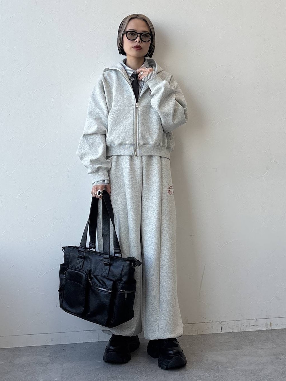 ブラック系のスニーカー、ブラック系のボストンバッグ、グレー系のパーカーを着用したレディースの冬コーディネートの6枚目の写真