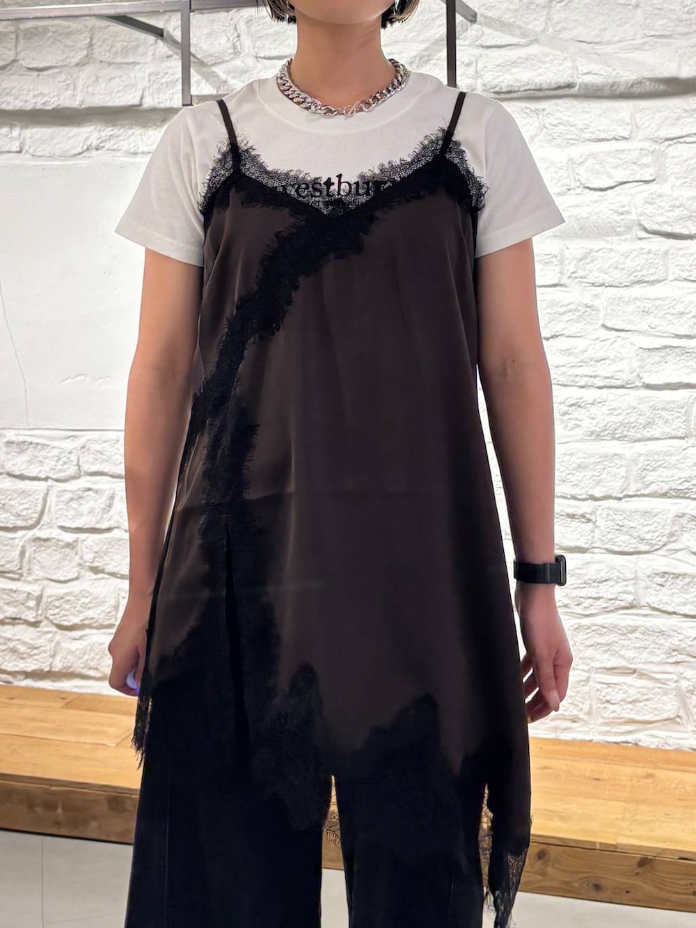 ブラック系のデニムパンツ、ブラウン系のチュニック、ホワイト系のTシャツ/カットソーを着用したレディースの夏コーディネートの4枚目の写真