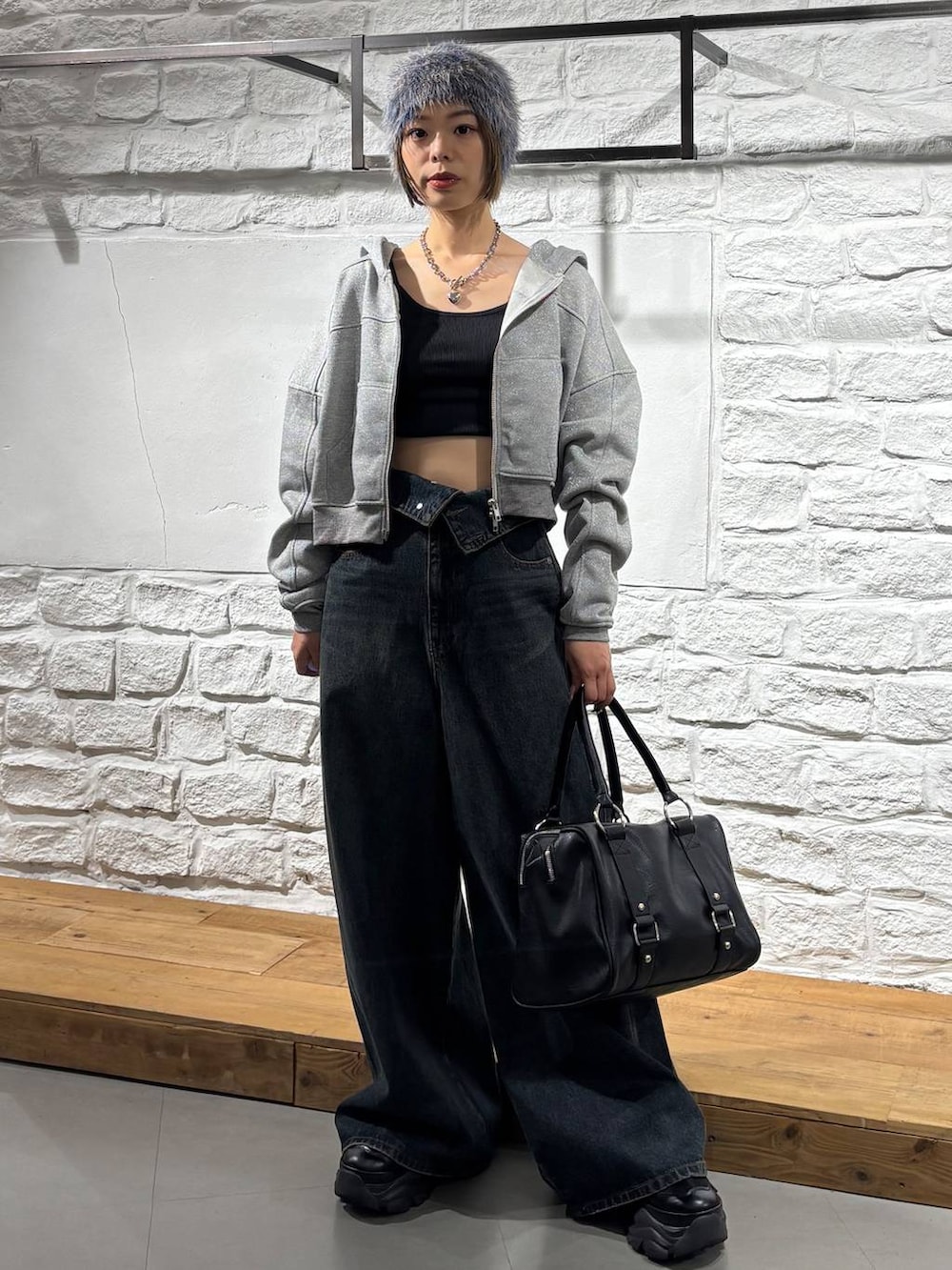 ブルー系のデニムパンツ、ブラック系のボストンバッグ、グレー系のパーカーを着用したレディースの秋コーディネートの2枚目の写真