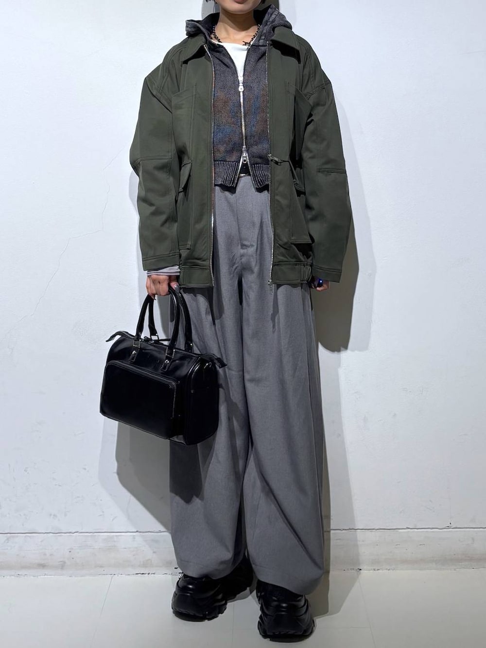 ブラック系のスニーカー、グレー系のパーカー、ブラック系のショルダーバッグを着用したレディースの春コーディネートの3枚目の写真