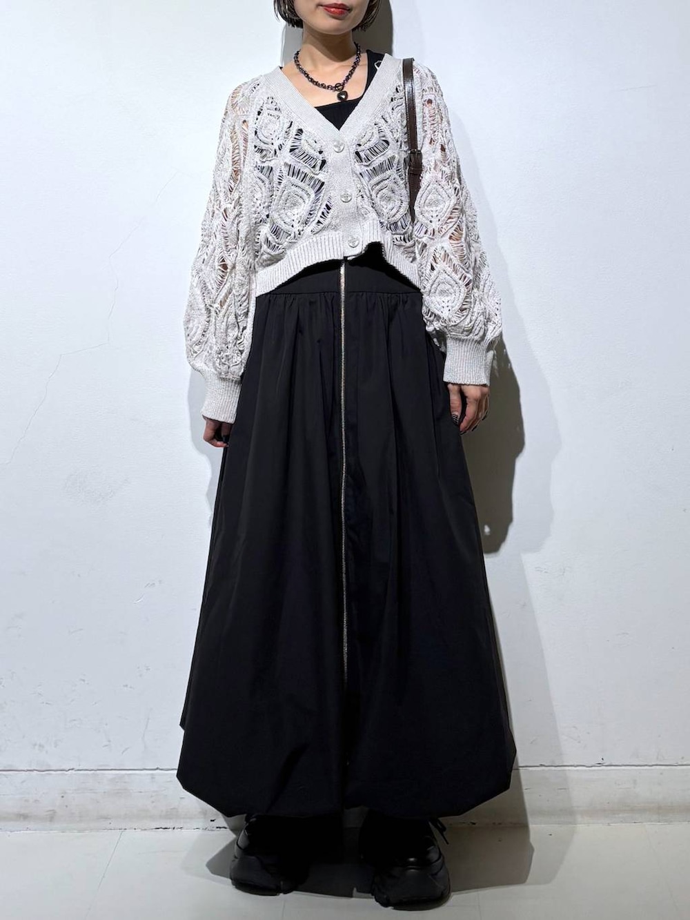 ブラック系のスニーカー、ベージュ系のカーディガン/ボレロ、ブラウン系のショルダーバッグを着用したレディースの春コーディネートの3枚目の写真