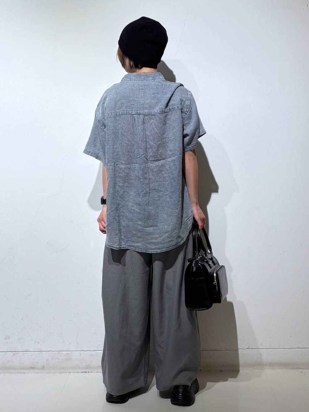 ブラック系のショルダーバッグ、グレー系のスラックス、グレー系のタンクトップを着用したレディースの春コーディネートの5枚目の写真