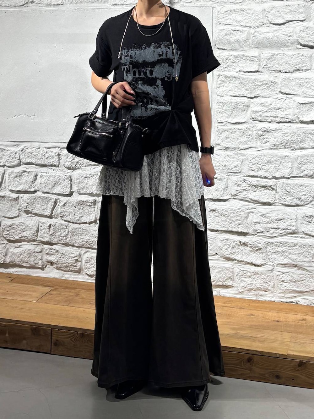ブラウン系のデニムパンツ、ブラック系のショルダーバッグ、ブラック系のTシャツ/カットソーを着用したレディースの夏コーディネートの2枚目の写真