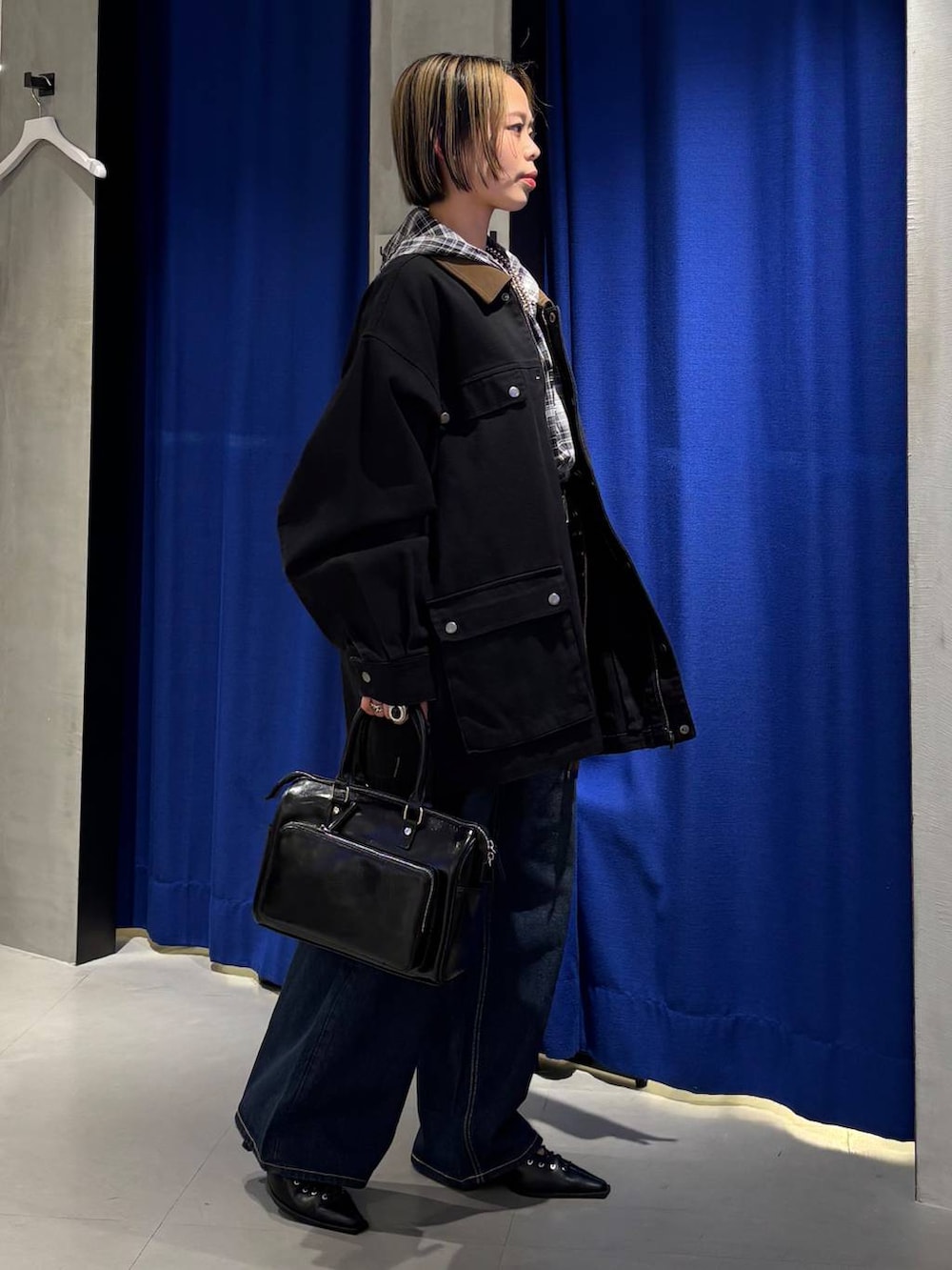 ブルー系のデニムパンツ、ブラック系のショルダーバッグ、ブラック系のサンダルを着用したレディースの春コーディネートの3枚目の写真