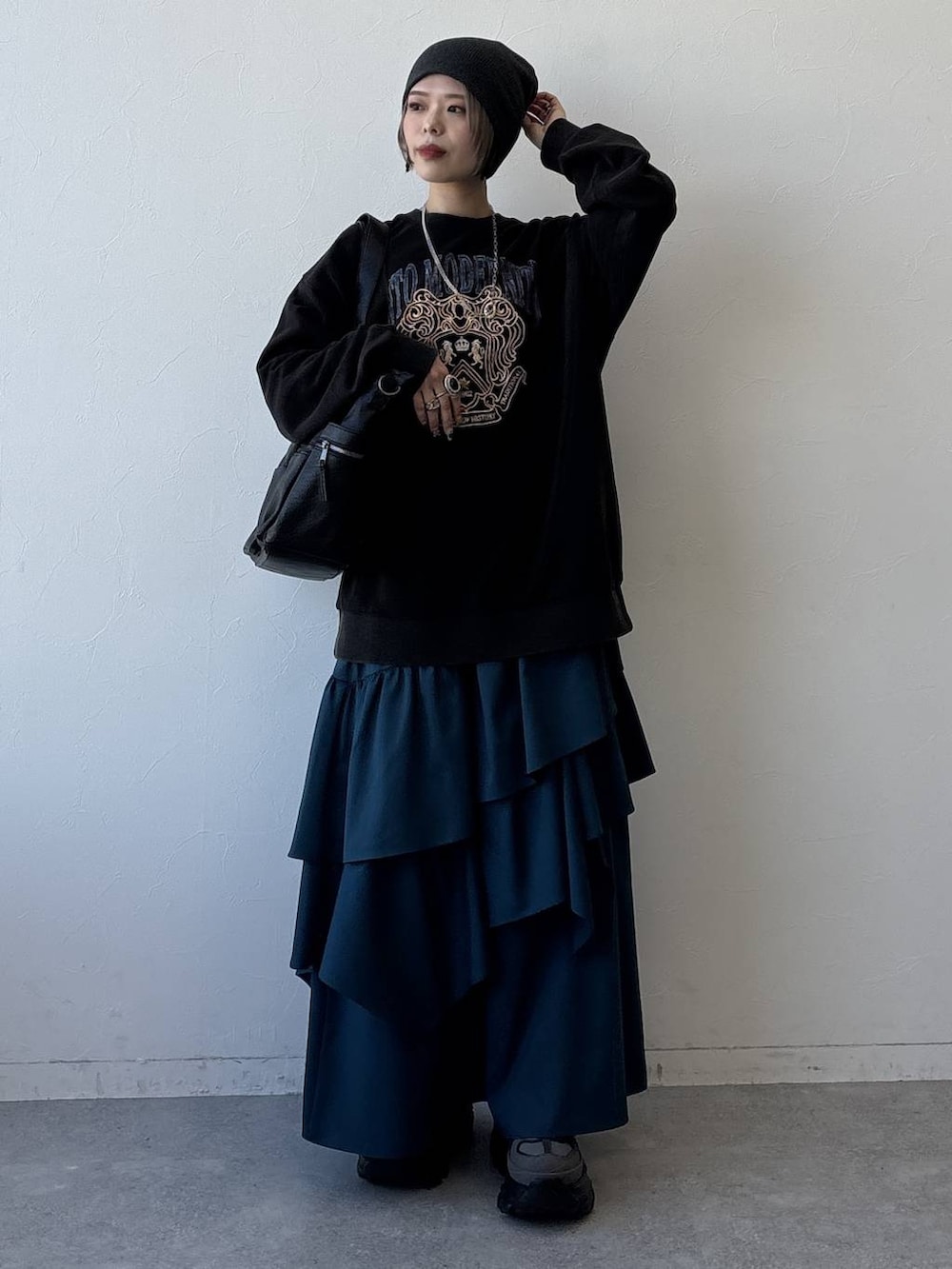 グレー系のスニーカー、ブラック系のボストンバッグ、ブルー系のスカートを着用したレディースの冬コーディネートの3枚目の写真