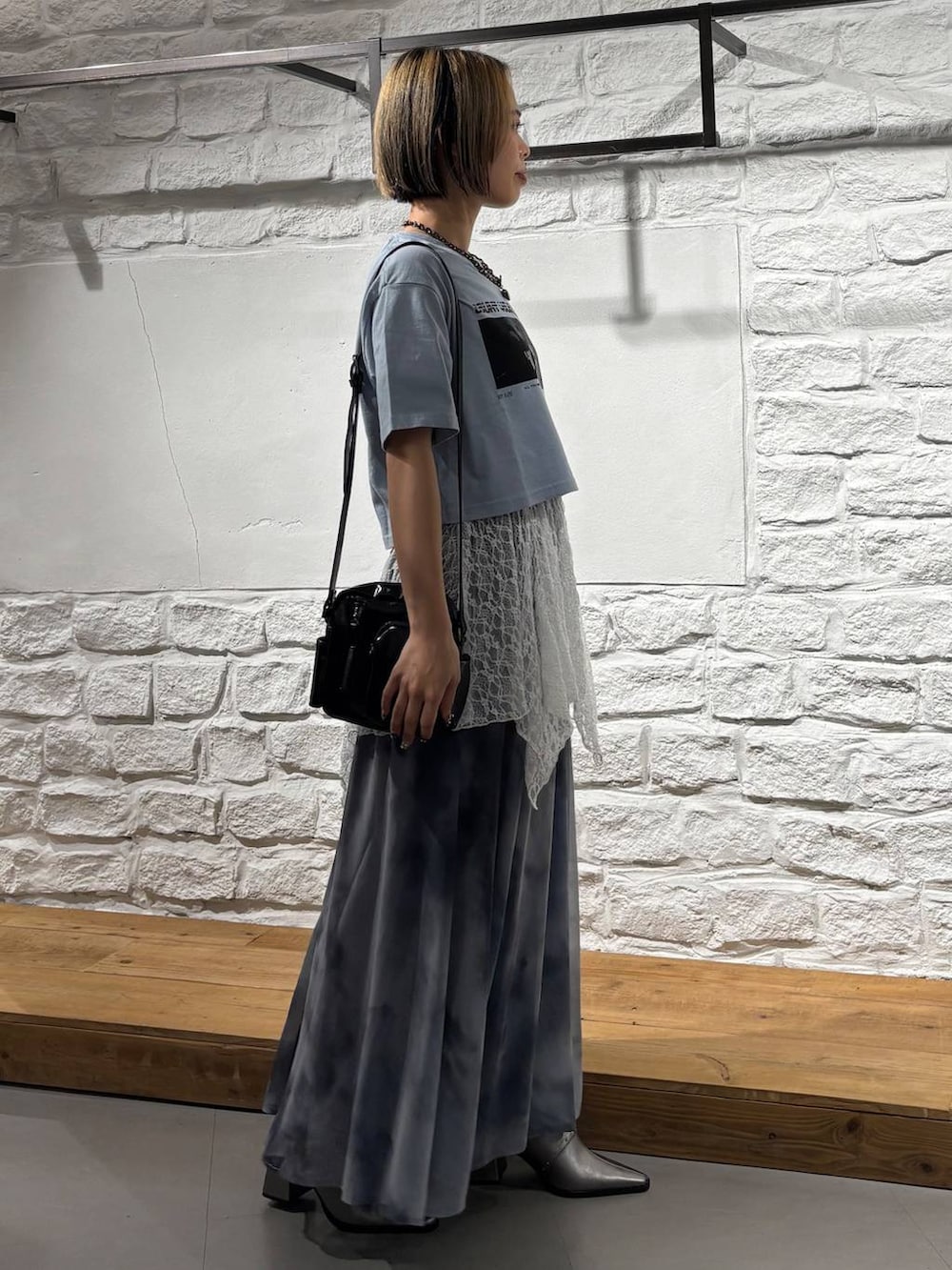 ブルー系のTシャツ/カットソー、グレー系のスカート、ブラック系のショルダーバッグを着用したレディースの夏コーディネートの5枚目の写真