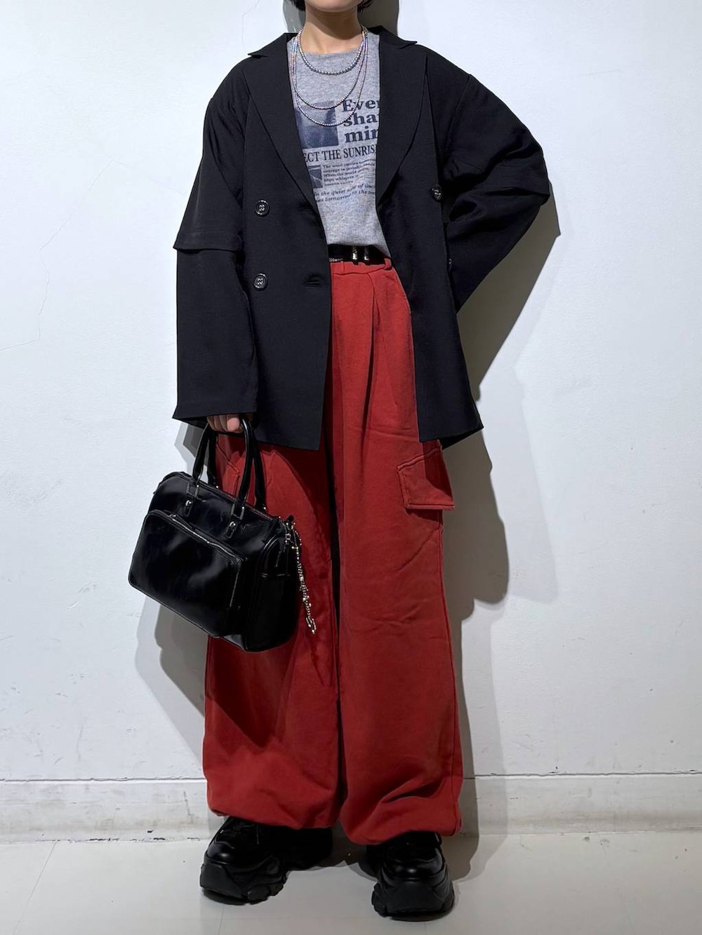 ブラック系のスニーカー、ブラック系のショルダーバッグ、ブラック系のテーラードジャケットを着用したレディースの春コーディネートの3枚目の写真