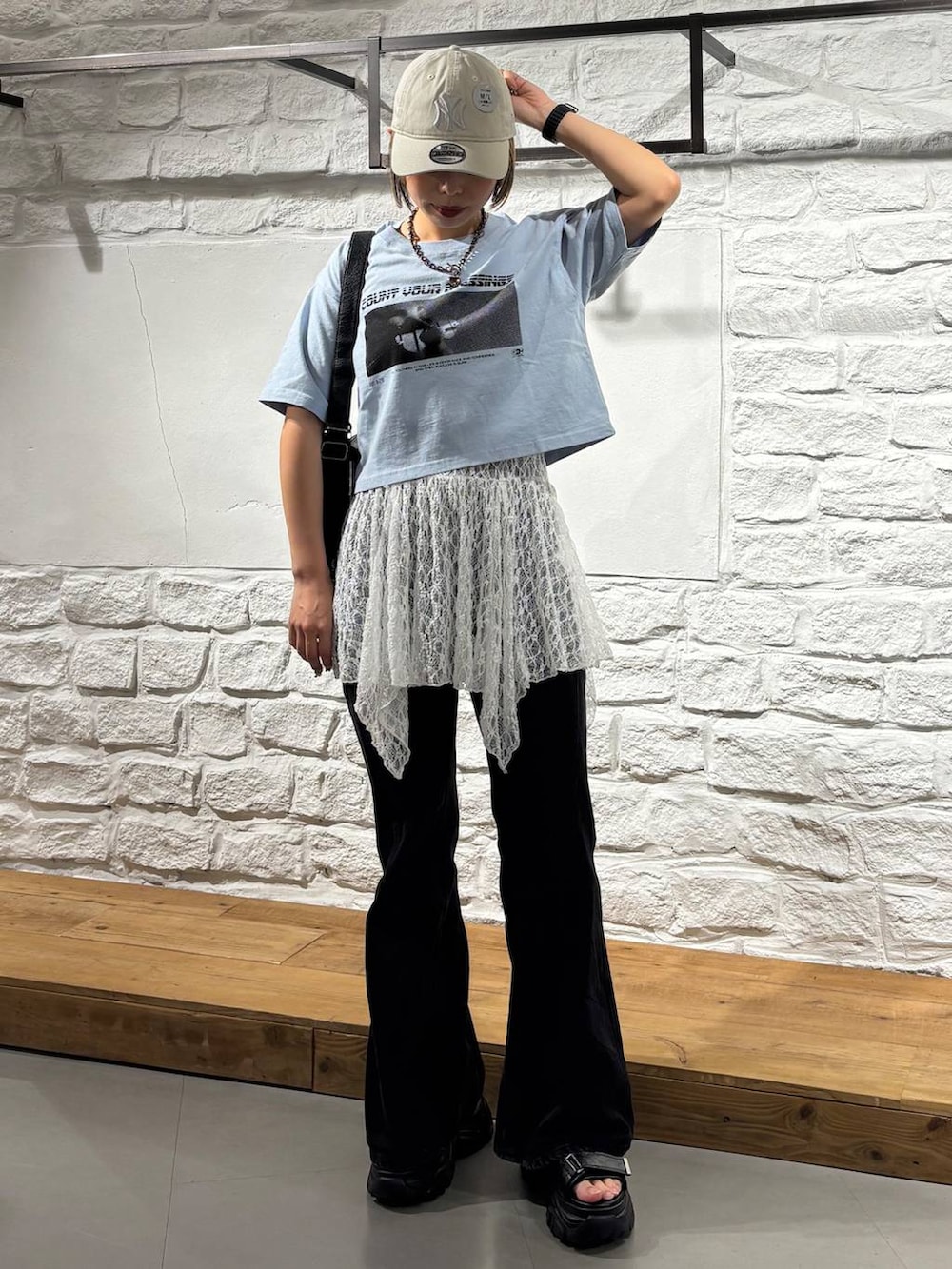 ブルー系のTシャツ/カットソー、ブラック系のデニムパンツ、ブラック系のショルダーバッグを着用したレディースの夏コーディネートの2枚目の写真