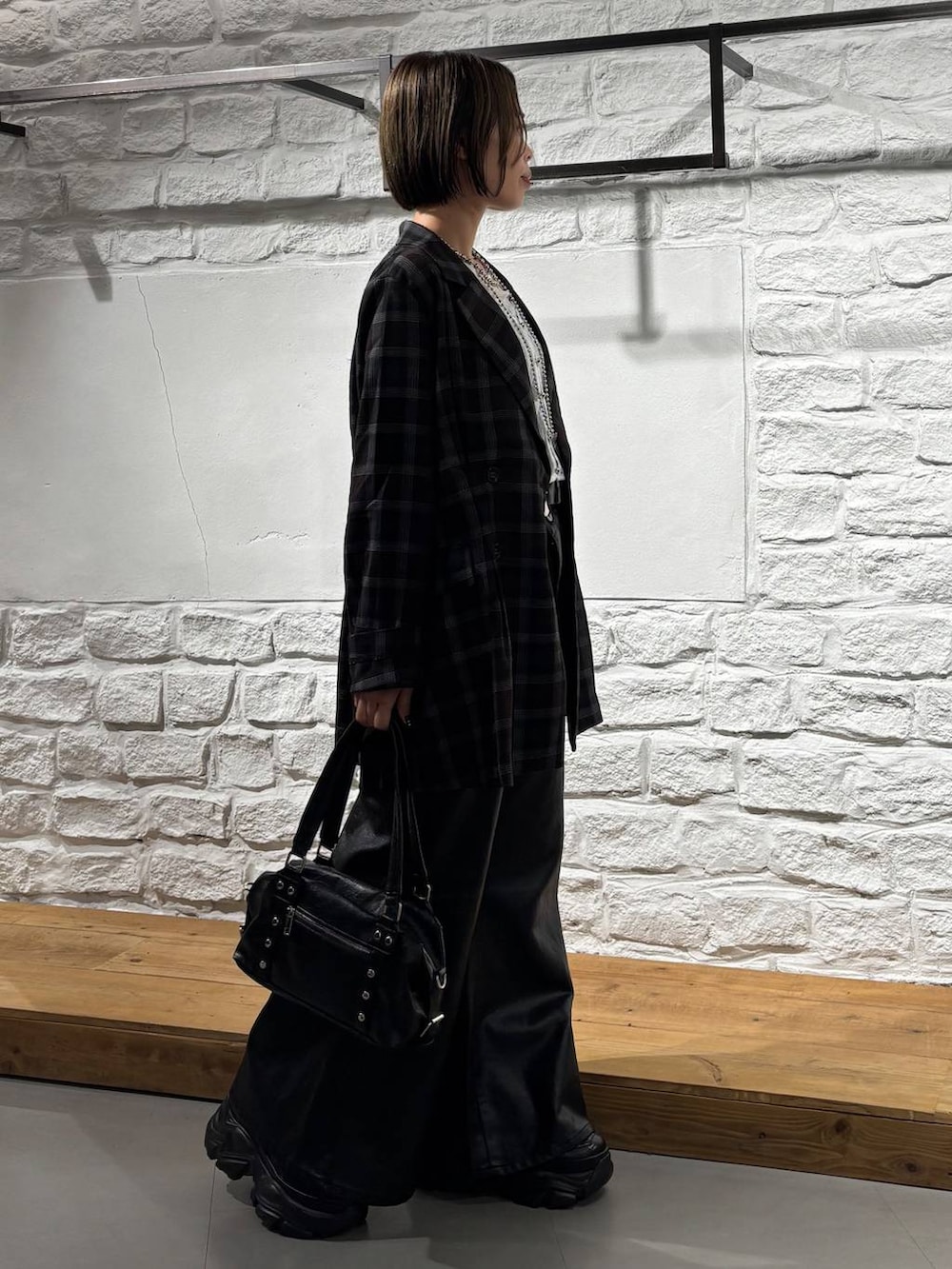 ブラック系のショルダーバッグ、ブラック系のデニムパンツ、ホワイト系のTシャツ/カットソーを着用したレディースの夏コーディネートの4枚目の写真